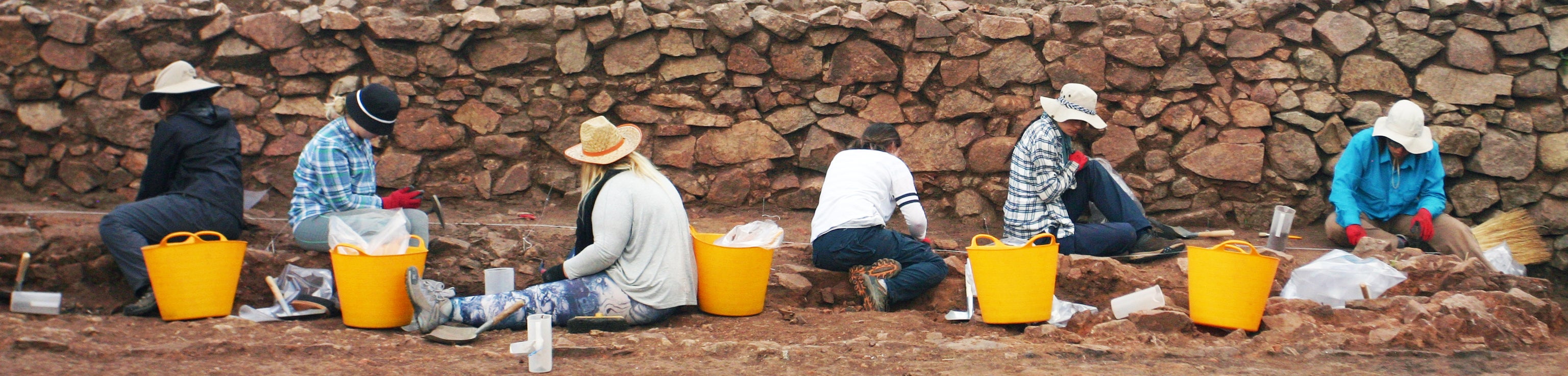 2016010299 A group of people sitting on a stone wall.